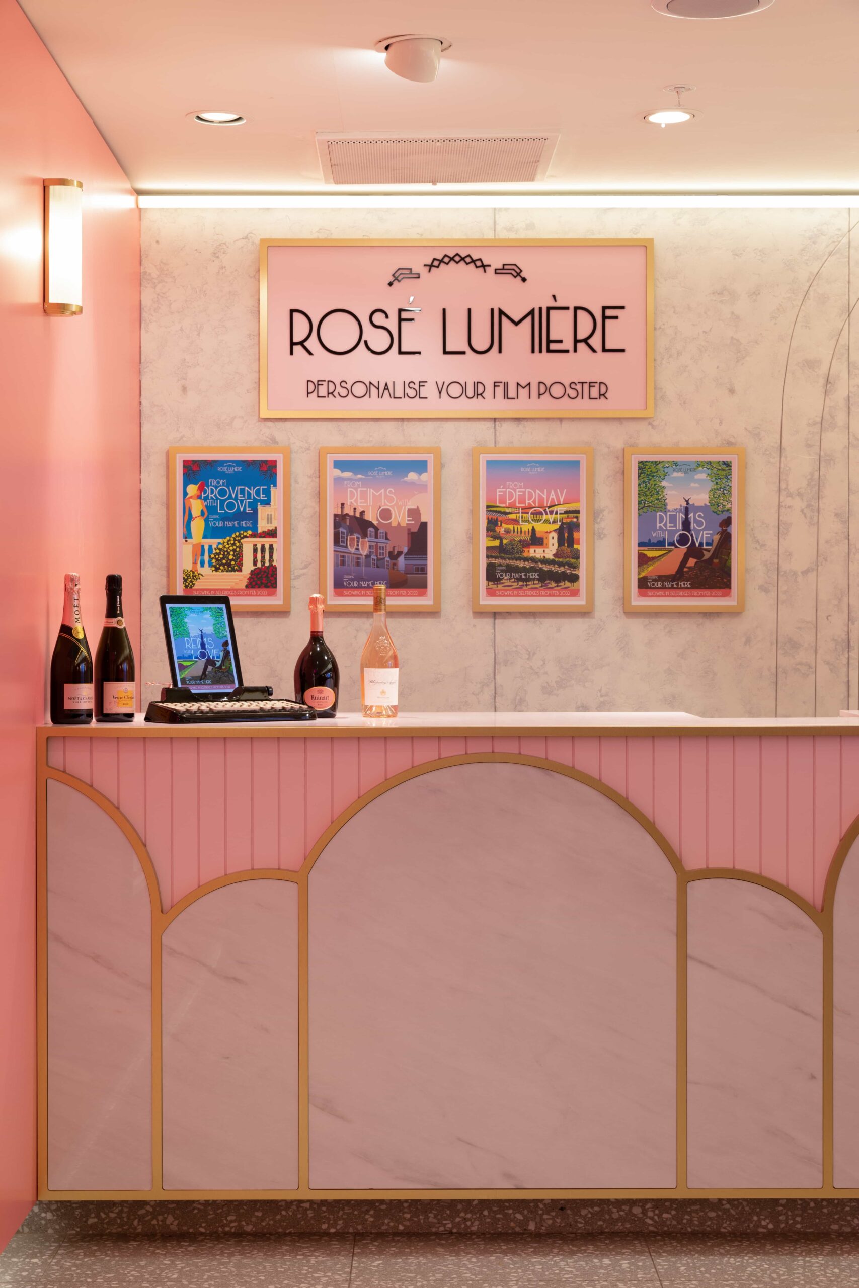 Barra de un bar de color rosa, con carteles y bebidas