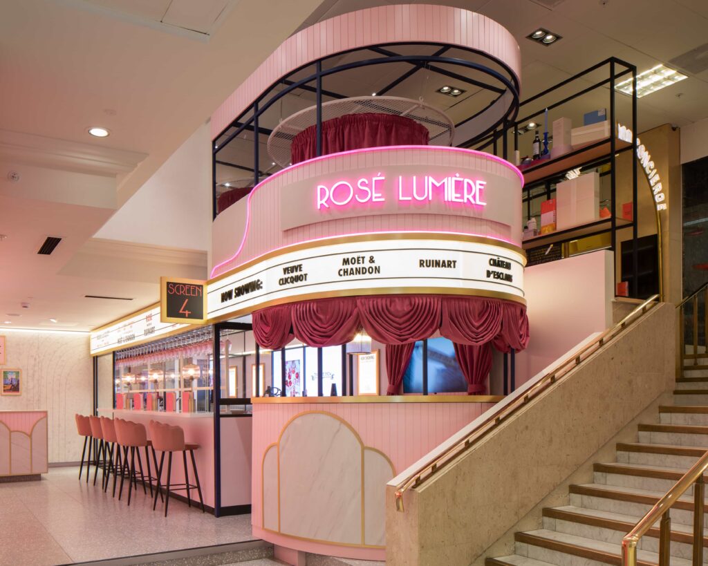 Interior del Rosé Lumière Bar, destacando un letrero lum inoso de color rosa, junto a un bar