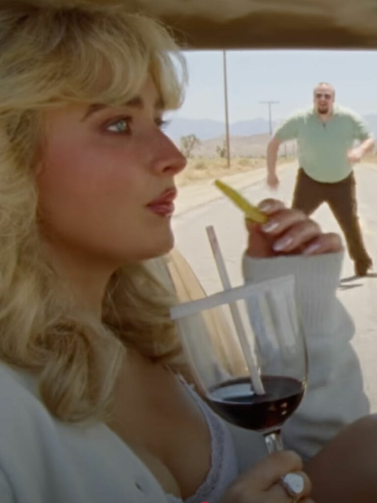 Sabrina carpenter en su vídeoclip comiendo caramelos Prada.